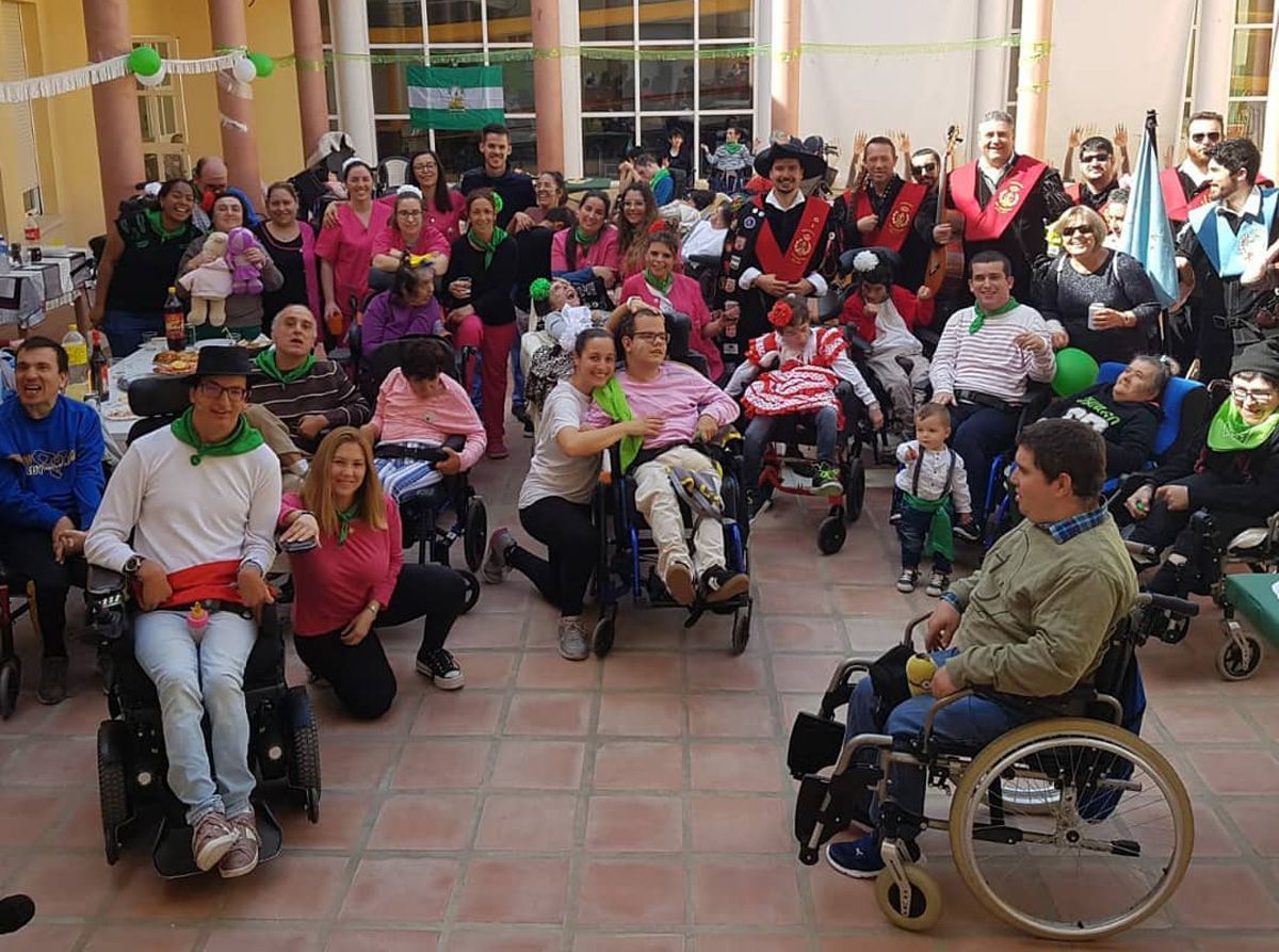 Personas usuarias, familias y profesionales de AMAPPACE en una celebración en el patio del centro